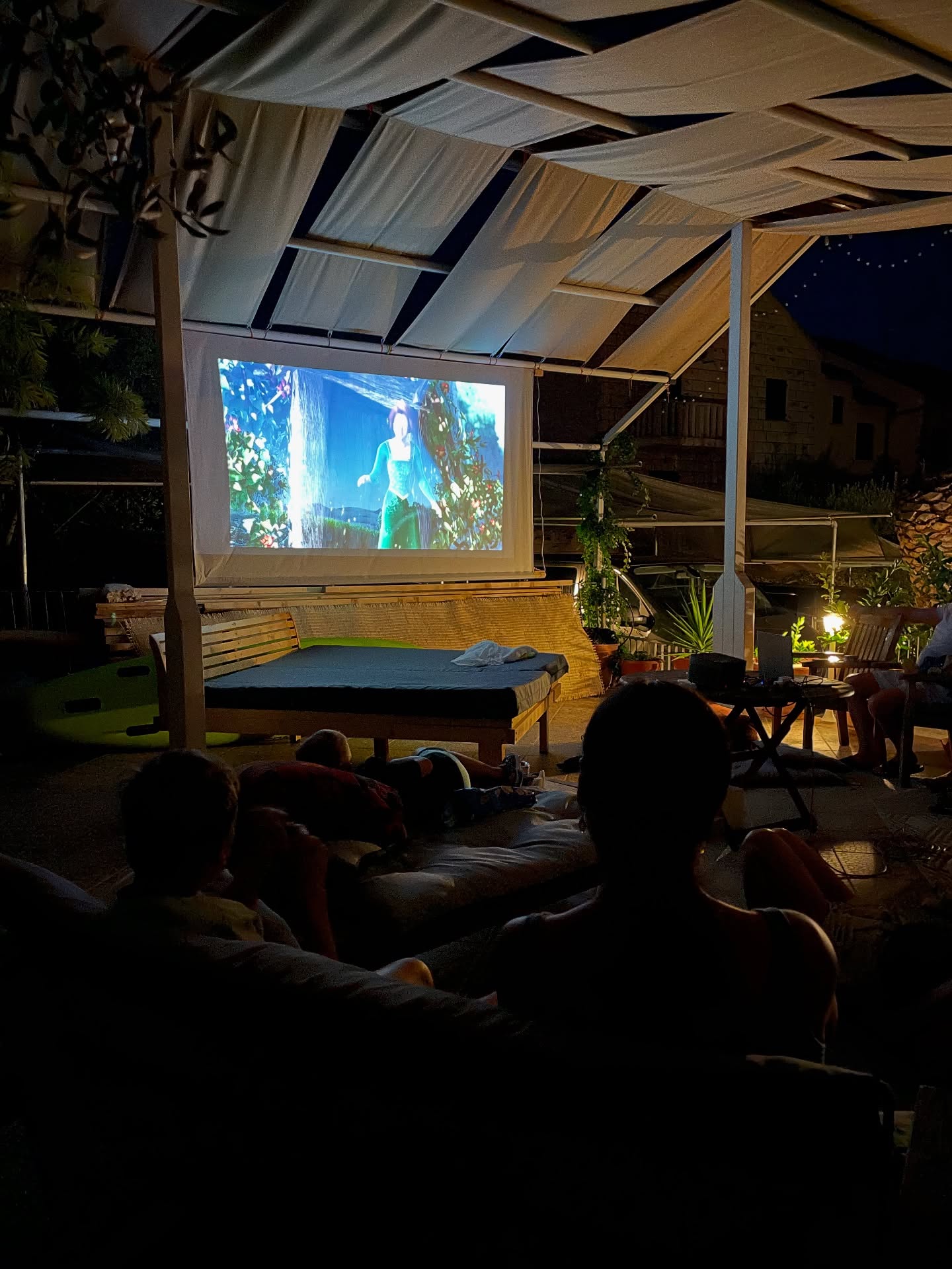 Wieczorne kino pod żaglami w ogrodzie
